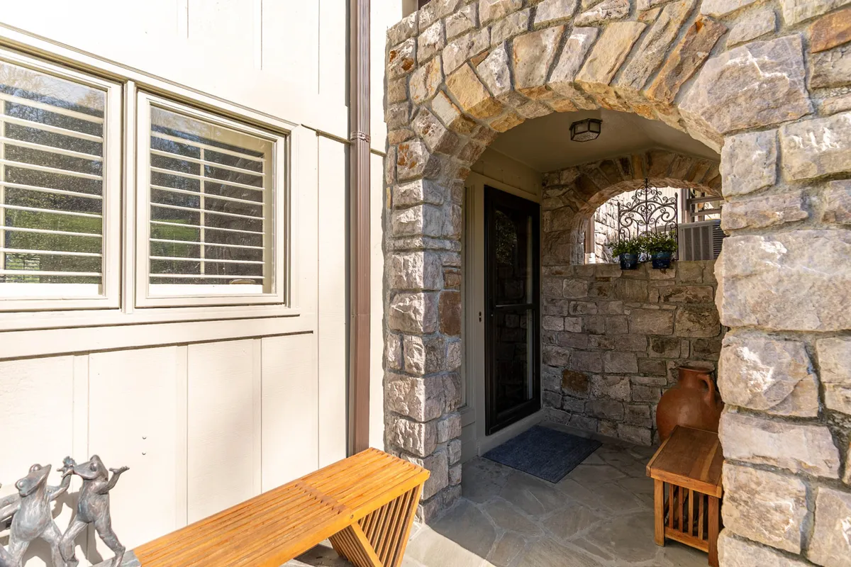 An arched stone entryway frames a wooden bench and decorative potted plants, blending architectural elements with touches of nature. The scene evokes a sense of arrival and anticipation, hinting at the adventure and relaxation awaiting just beyond the doorstep.